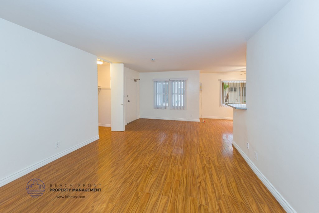 a living room and dining room with wood floors and white walls