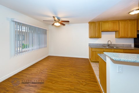 a kitchen with a wood floor and a ceiling fan