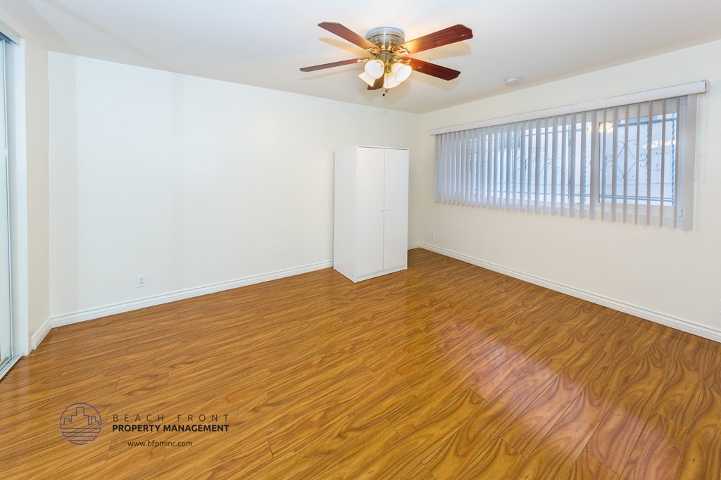 a living room with wood flooring and a ceiling fan