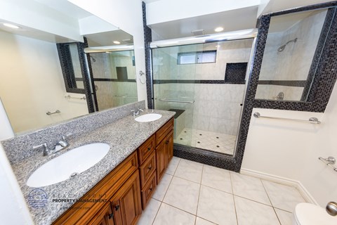 a bathroom with two sinks and a shower