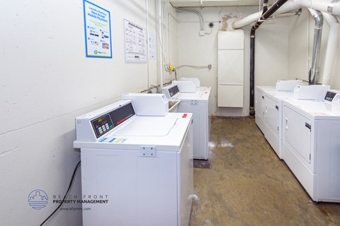 a laundry room with three washers and three washing machines