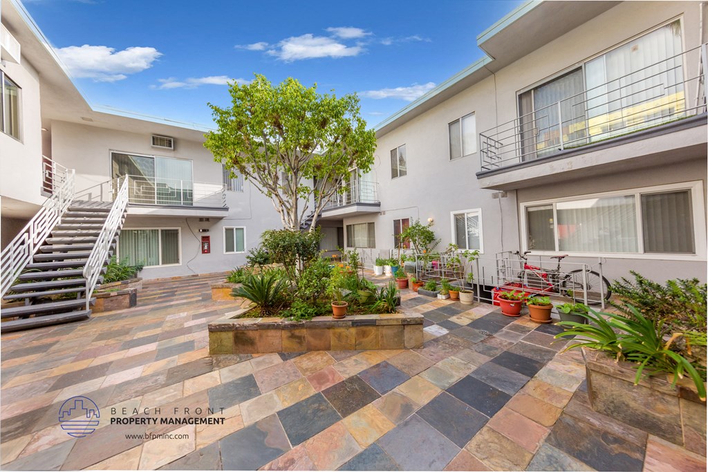 the courtyard of a condo building with plants and a staircase