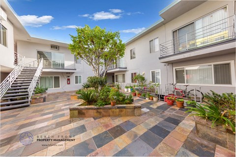 the courtyard of a condo building with plants and a staircase