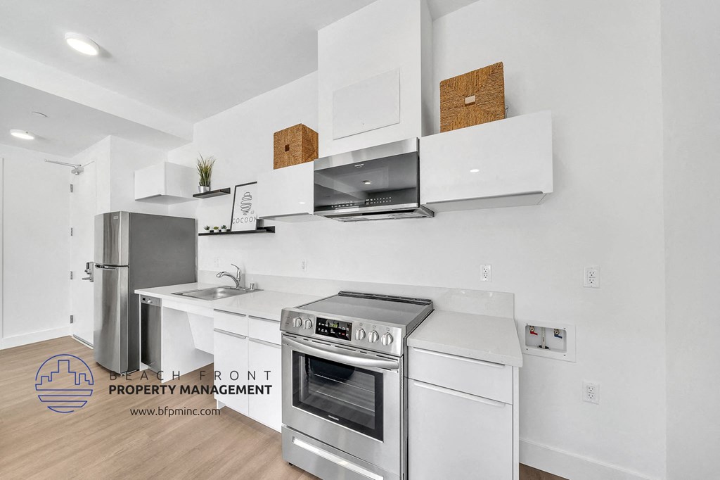 a white kitchen with stainless steel appliances and a stainless steel refrigerator