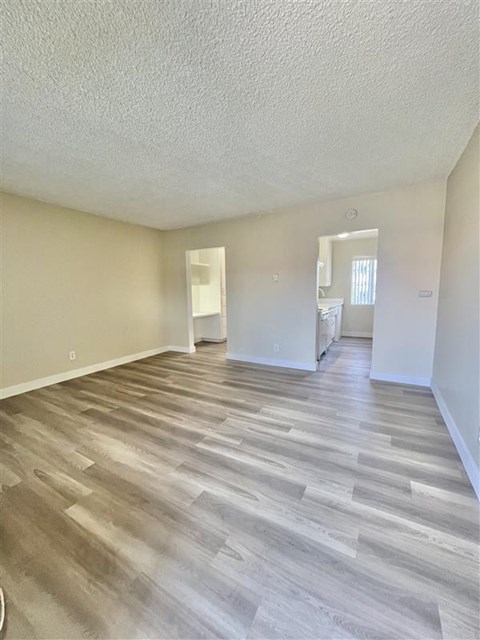 A room with wooden flooring and white walls.