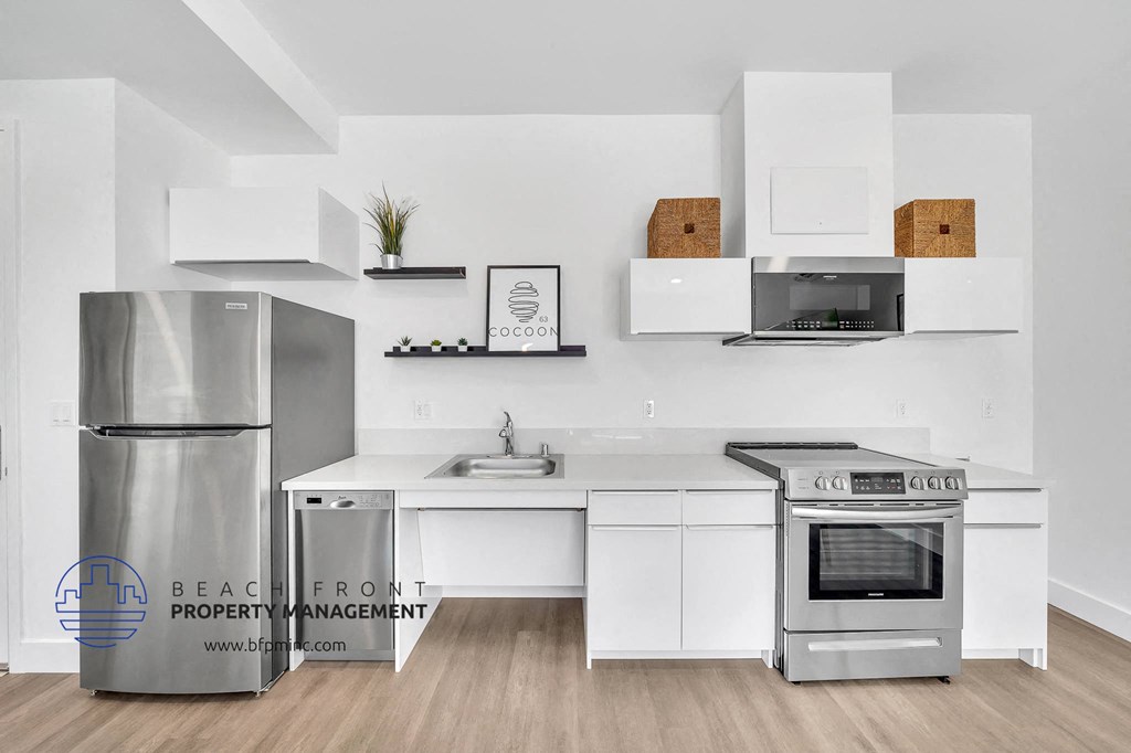 a white kitchen with stainless steel appliances and white counters