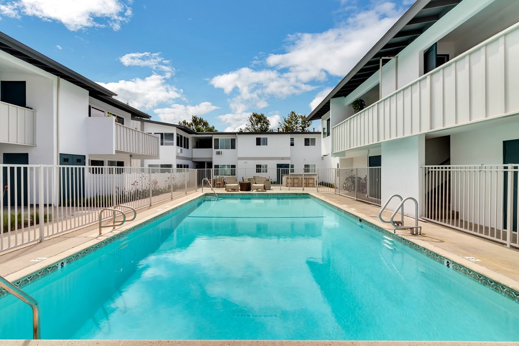 A large swimming pool in front of a white building.