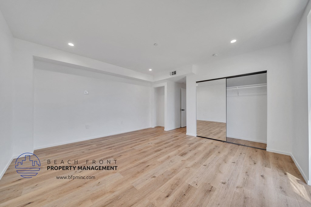 a renovated living room with white walls and wood flooring