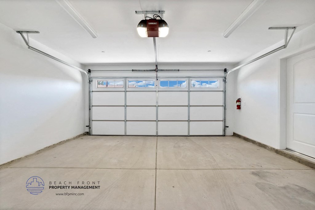 a white garage with white doors and a wood floor