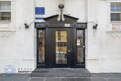 The front door of a building with a sign that says "BEACH FRONT PROPERTY MANAGEMENT".