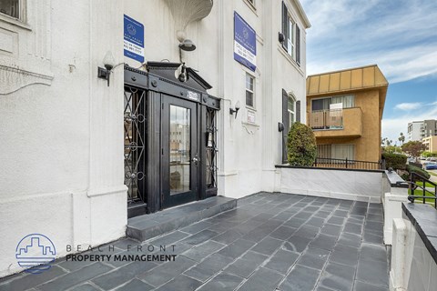 A building entrance with a sign for Beach Front Property Management.