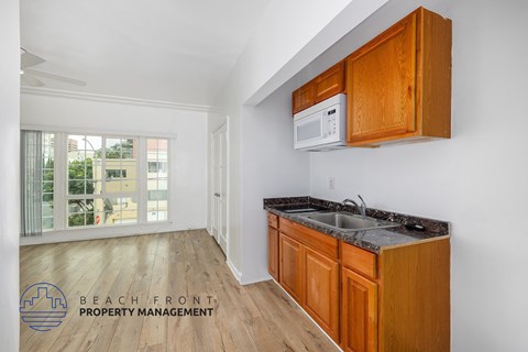 A kitchen with wooden cabinets and a white microwave.
