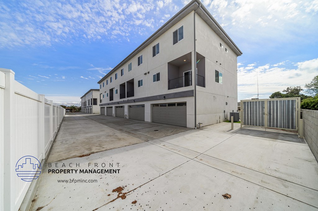 a large white building with a parking lot