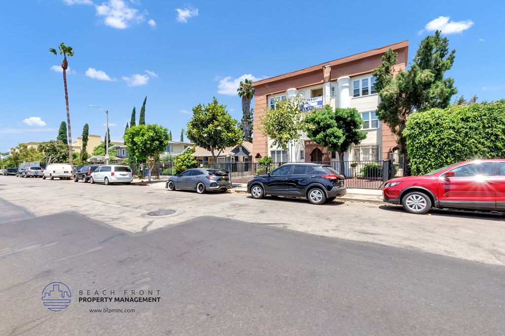 a parking lot with cars parked in front of a building