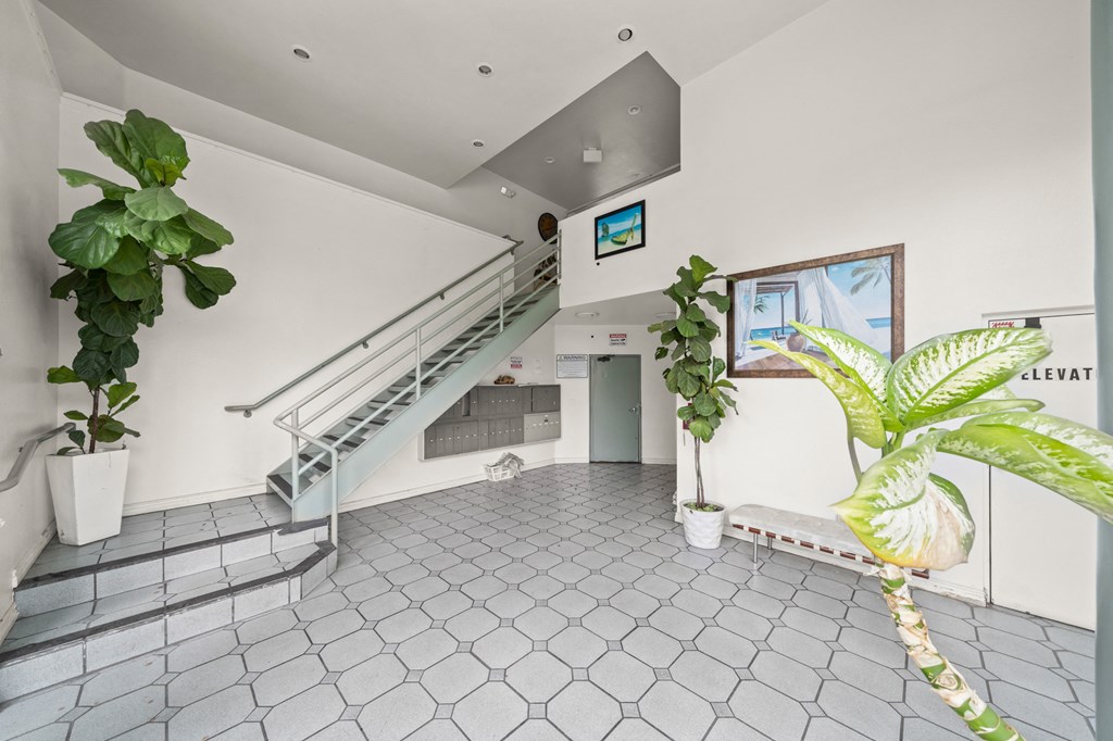 the lobby of a building with stairs and plants