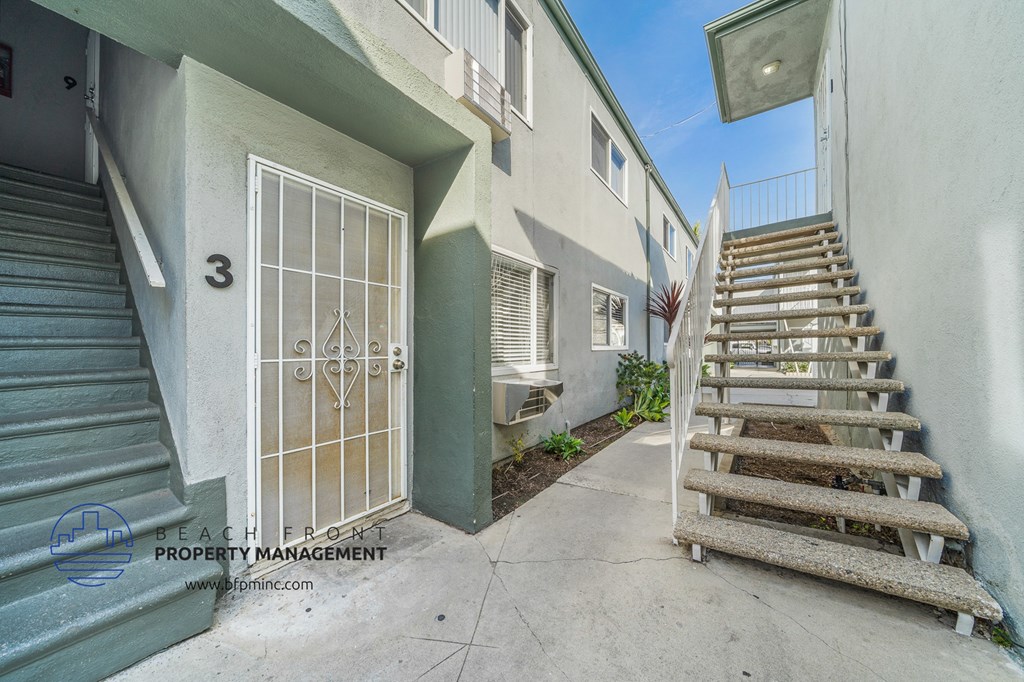 a staircase leading up to a door next to a building