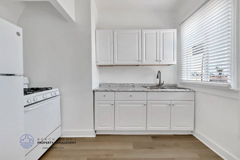 A kitchen with white appliances and cabinets.