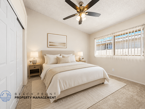 A bedroom with a large bed and a ceiling fan.