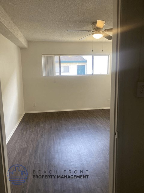 an empty room with a window and wood floors