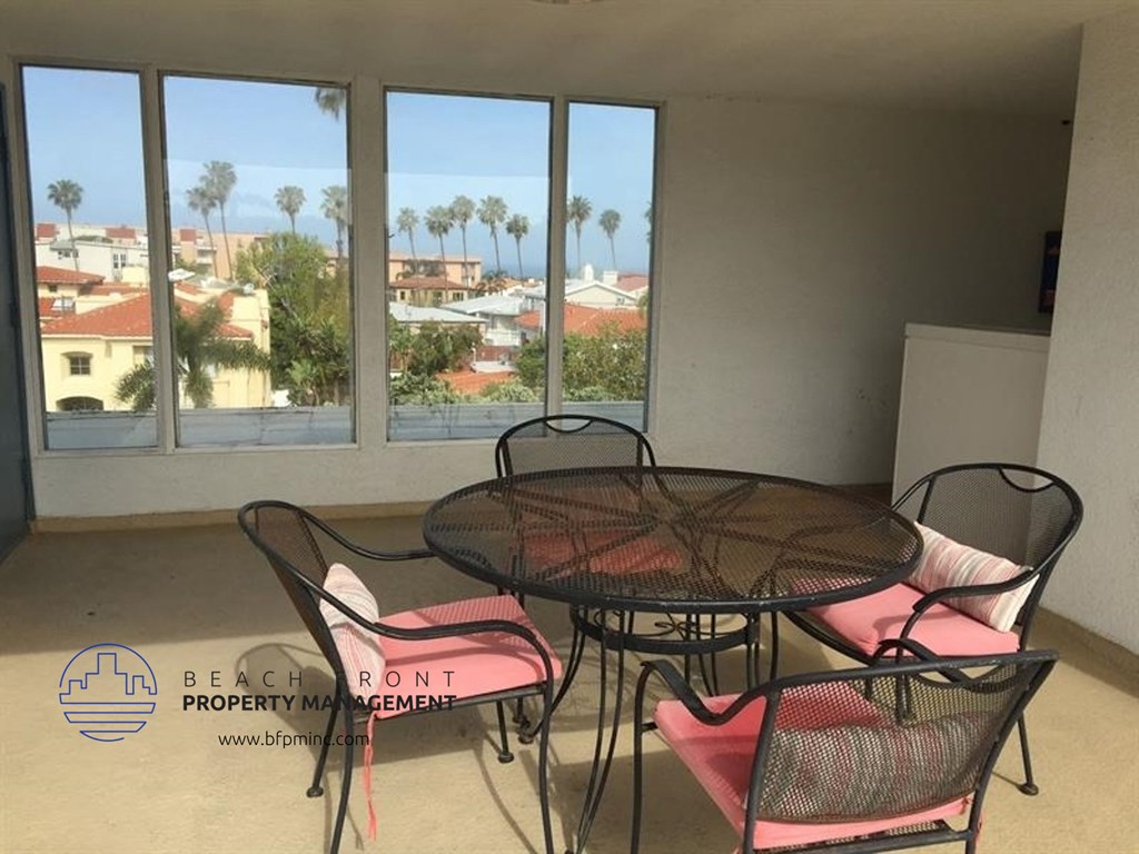 a living room with a table and chairs and a balcony