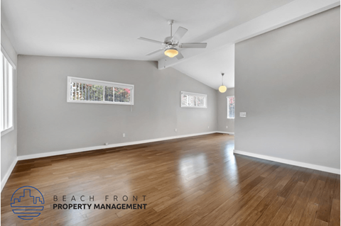 the living room and dining room with hardwood flooring and a ceiling fan