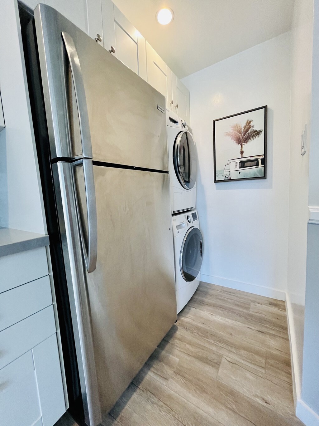 a washer and dryer in a kitchen with a refrigerator and a washing machine