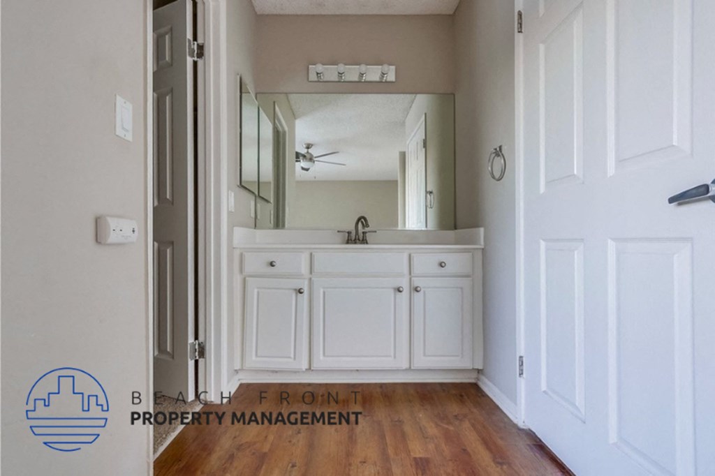 a bathroom with white cabinets and a sink and a mirror