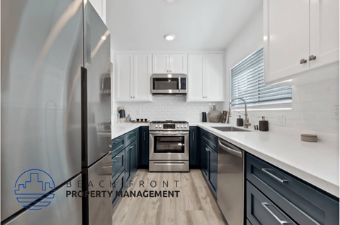 a kitchen with blue and white cabinets and stainless steel appliances