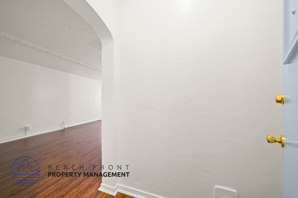 A room with a wooden floor and a white door.