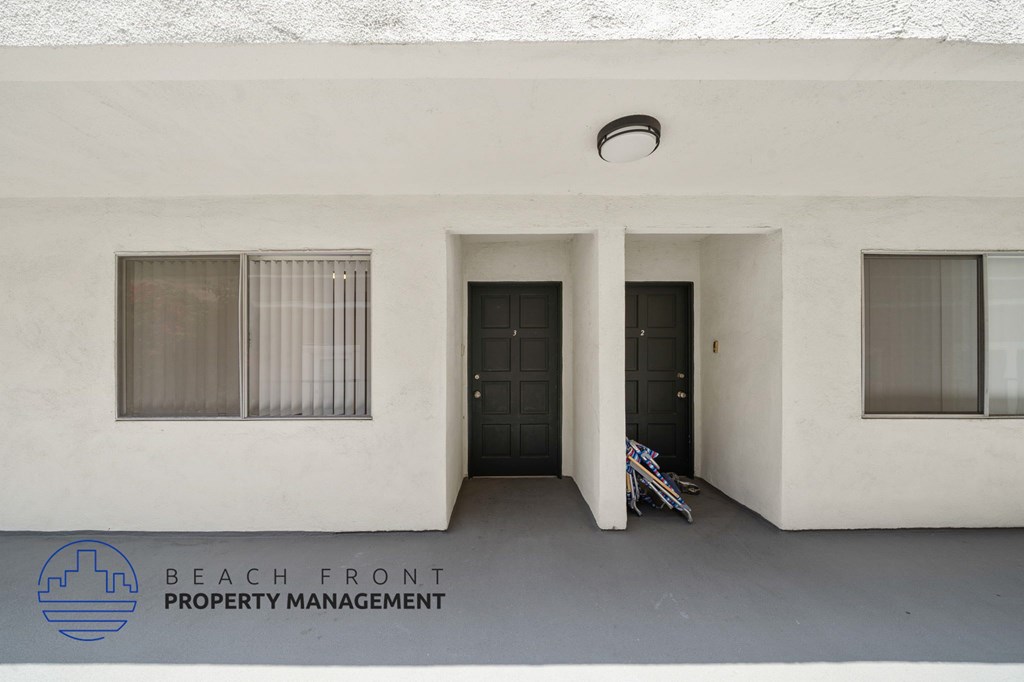 A white building with a sign that says Beach Front Property Management.