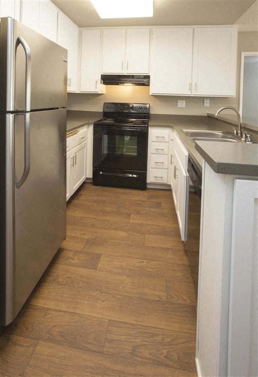 a kitchen with white cabinets and a black stove and refrigerator