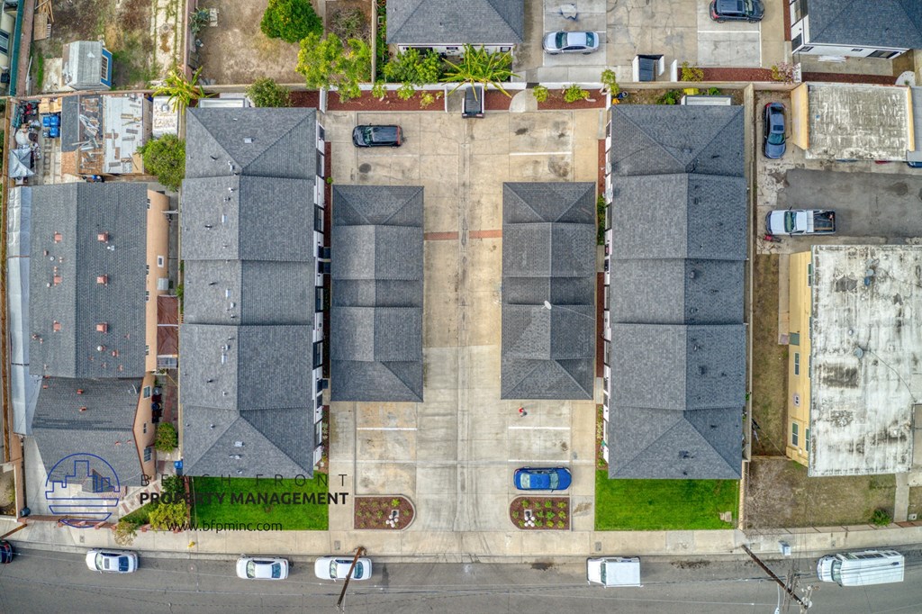 an aerial view of houses with gray roofs and a parking lot