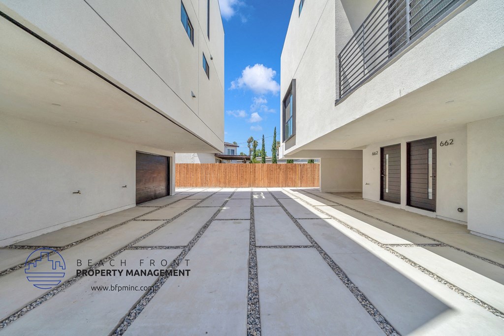 a courtyard between two buildings with a blue sky in the background
