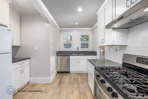 A kitchen with white cabinets and a black stove top.