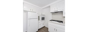 A kitchen with white appliances and cabinets.