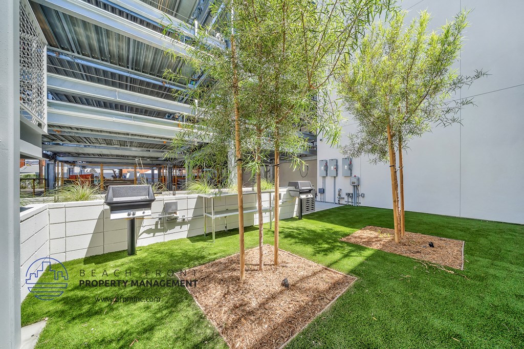 a grassy area with trees in the middle of an office building