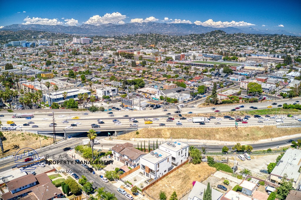 an aerial view of the city and highways with mountains in the background