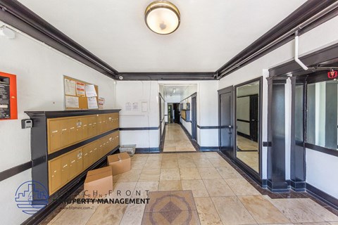 A hallway with a bench, a mirror, and a sign that says "CHN FRONT".
