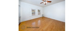 A room with wooden flooring and a ceiling fan.