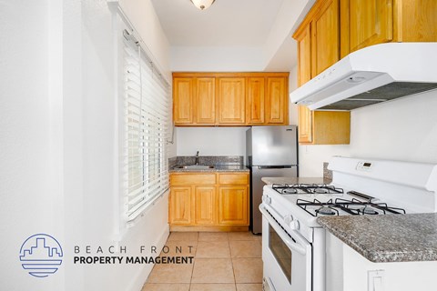 A kitchen with a stove top oven and a refrigerator.