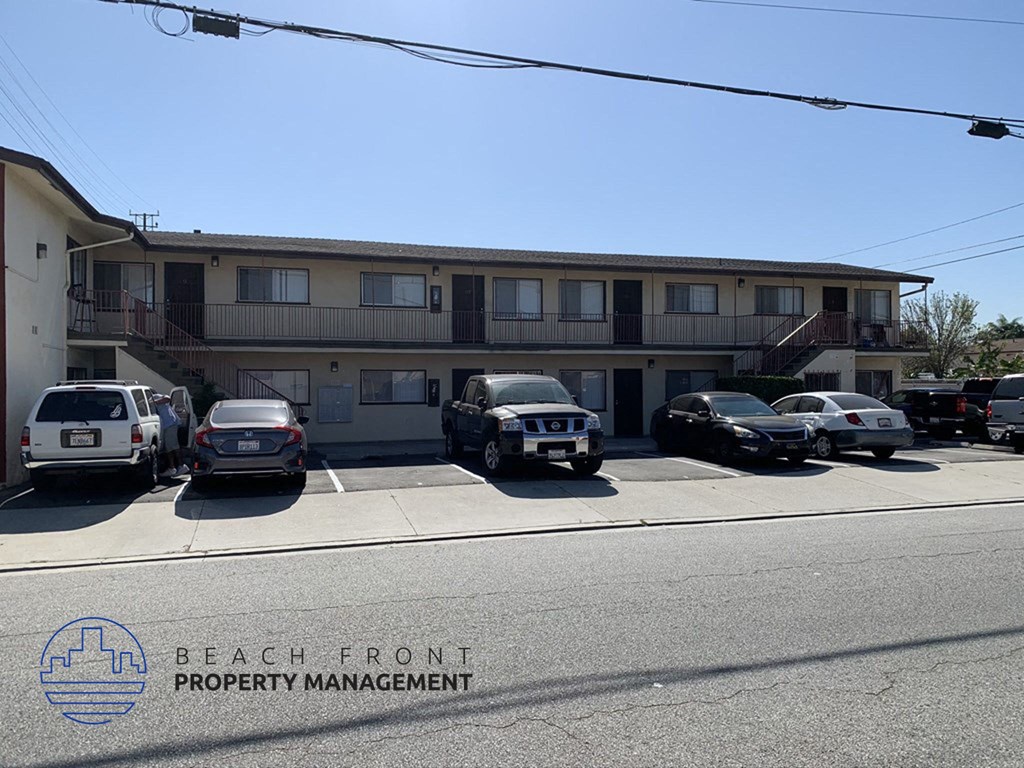 a parking lot with cars in front of an apartment building