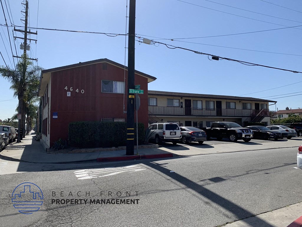 a building on the corner of a street with parked cars