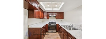 A kitchen with wooden cabinets and a stove top oven.