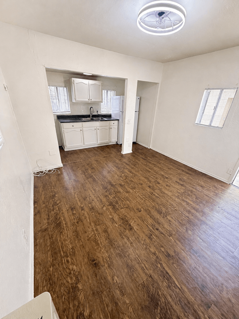 A room with wooden flooring and white walls.