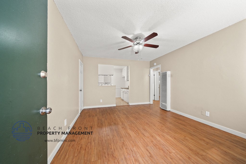 a living room with wood flooring and a ceiling fan