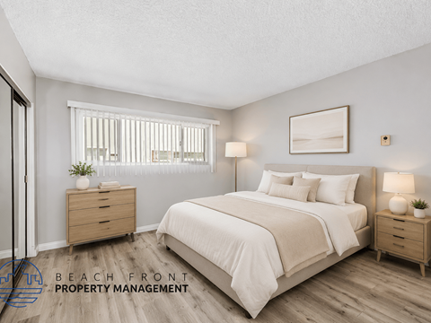 A bedroom with a large bed, two nightstands, and a window with blinds.