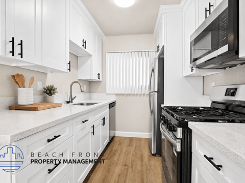 A kitchen with white cabinets and a black stove top.