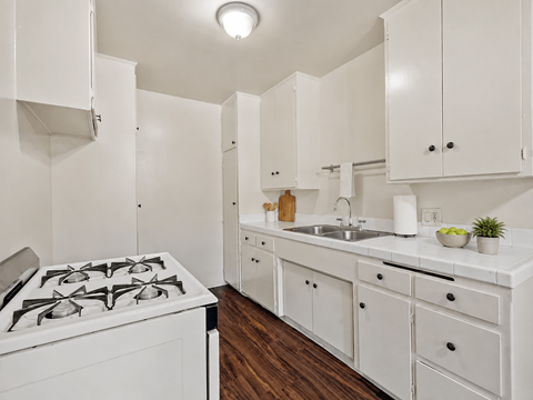 A white kitchen with a stove and cabinets.