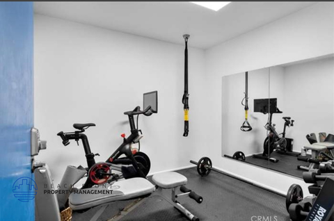 a workout room with bikes and weights in a home gym