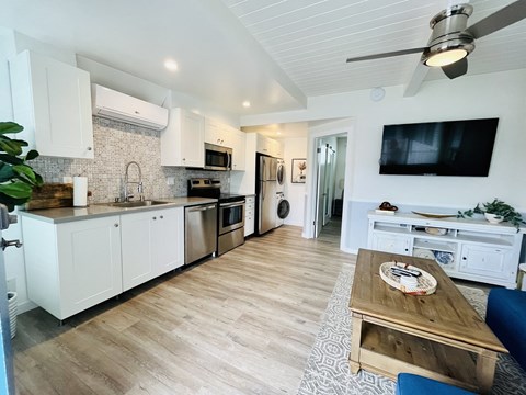 a kitchen and living room with a tv and a table